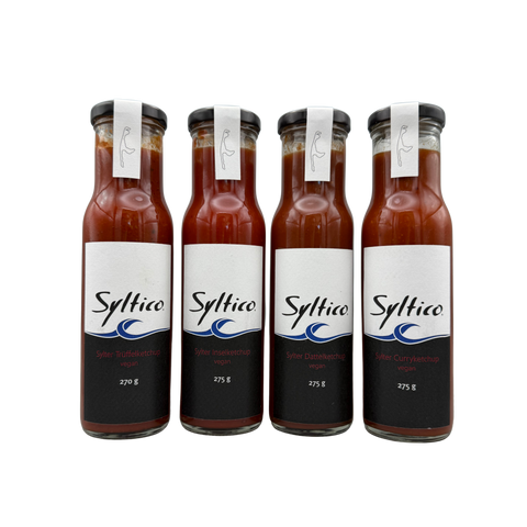 4 Flaschen der Marke Syltico in dem verschienden Ketchup Sorten der Marke sind. Sylter Trüffelketchup, Sylter Inselketchup, Sylter Dattelketchup, Sylter Curryketchup. Weiß Schwarzes Ektikett mit Blauer Welle 
